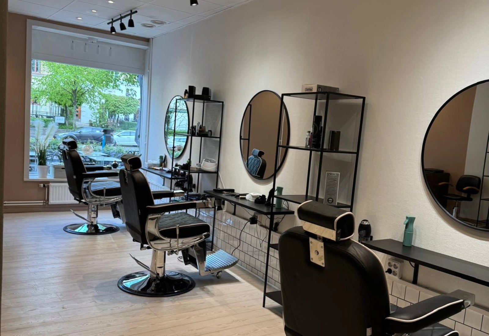 Salongen på Linnégatan 51 med barberarstolar, speglar och fönster ut mot gatan